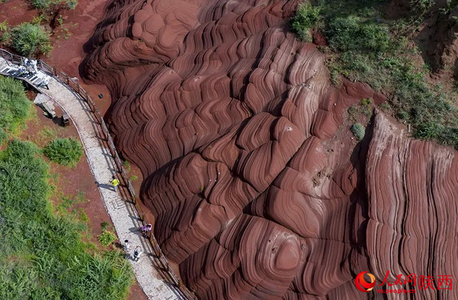 นักท่องเที่ยวชื่นชมภูมิทัศน์ทางธรณีวิทยาอันเป็นเอกลักษณ์หลังฝนตก ณ แหล่งท่องเที่ยว หุบเขาเกรียวคลื่นไร้ทะเล ตำบลหลงโจว อำเภอจิ้งเปียน เมืองอวี๋หลิน มณฑลส่านซี ทางตะวันตกเฉียงเหนือของจีน (People's Daily Online)